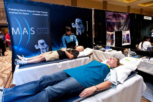 Jeff Thomson, left, and Belinda Barry try out the pulsating electro magnetic matts in the MAS booth while attending the Official Star Trek Convention at the Rio in Las Vegas on Saturday, Aug. 10, 2013.